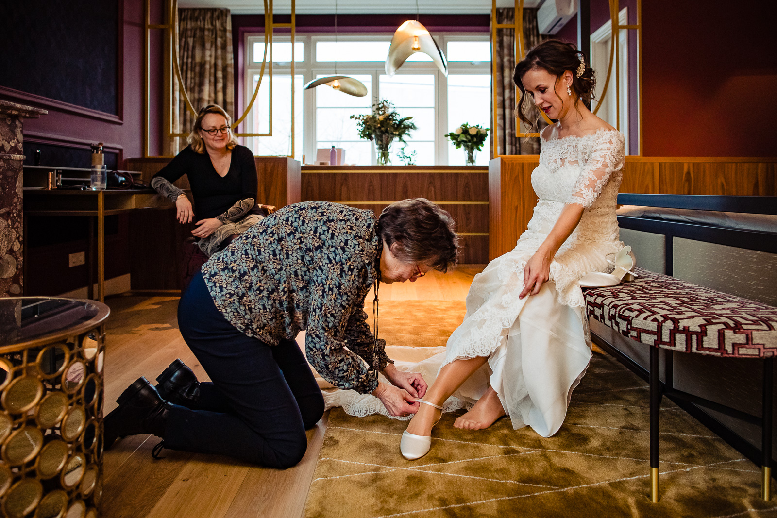 Trouwfotograaf Leiden moeder helpt bruid met trouwschoenen aandoen