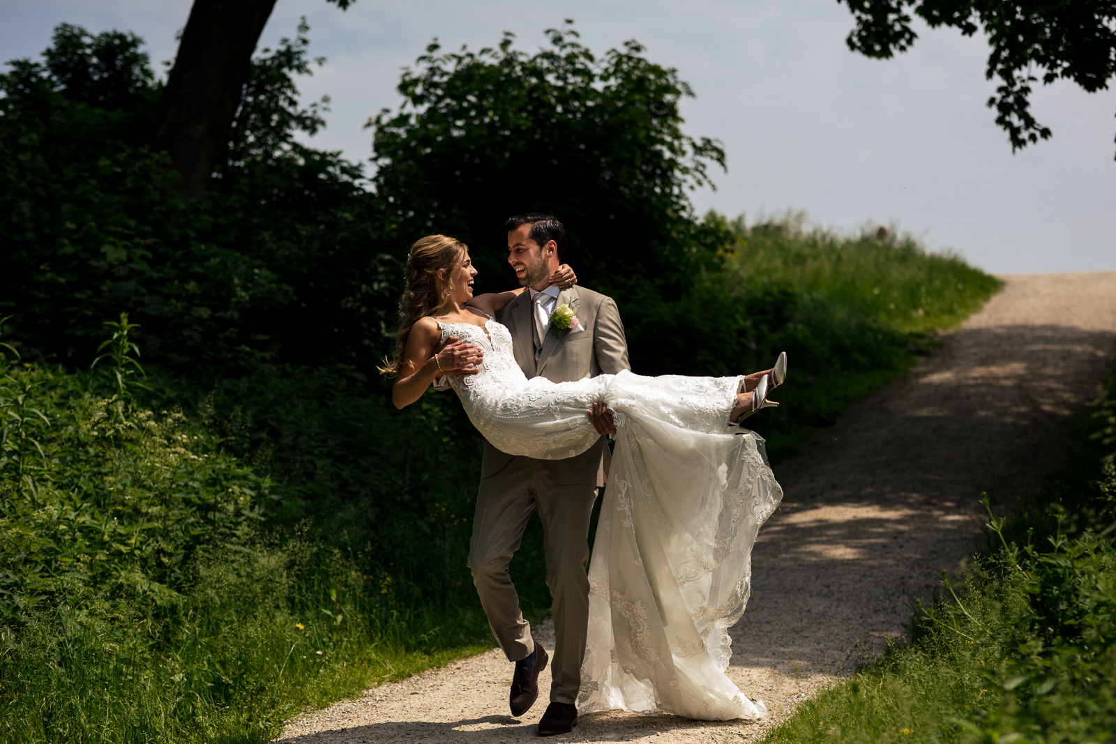 Bruidegom tilt bruid op tijdens de fotoshoot
