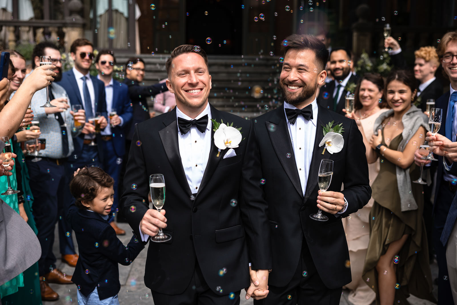 Grooms enter the reception with champagne in their hand and bubbles in the air