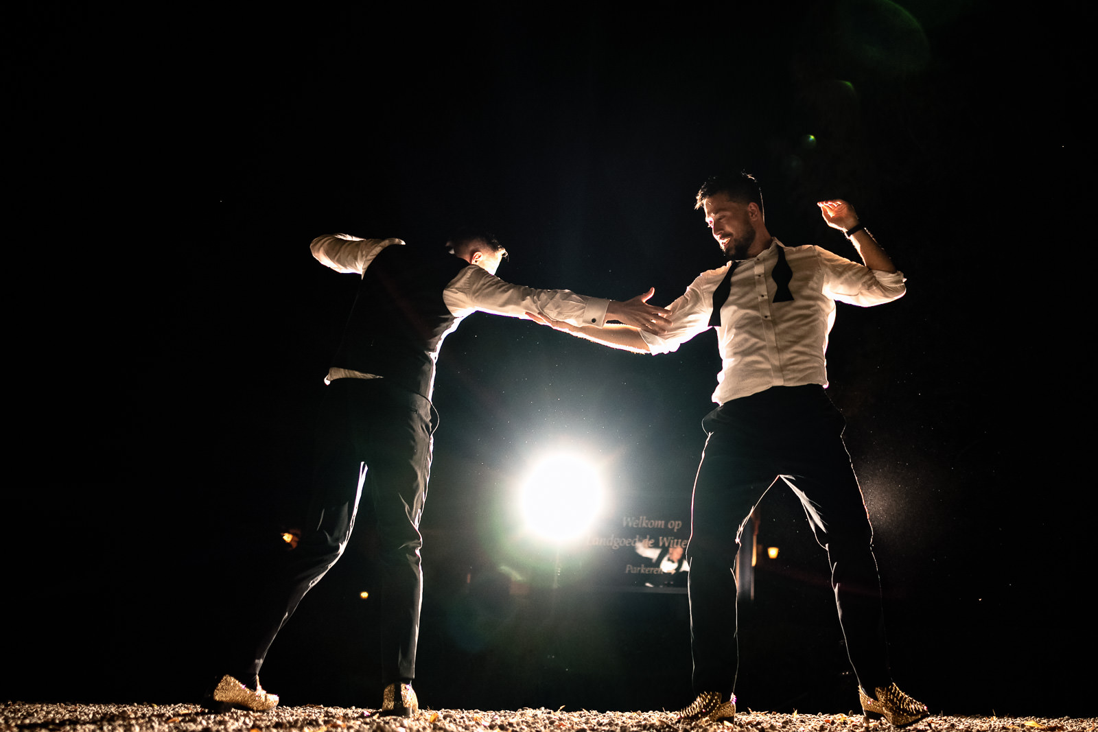 Two grooms dancing during a creative shoot in the dark