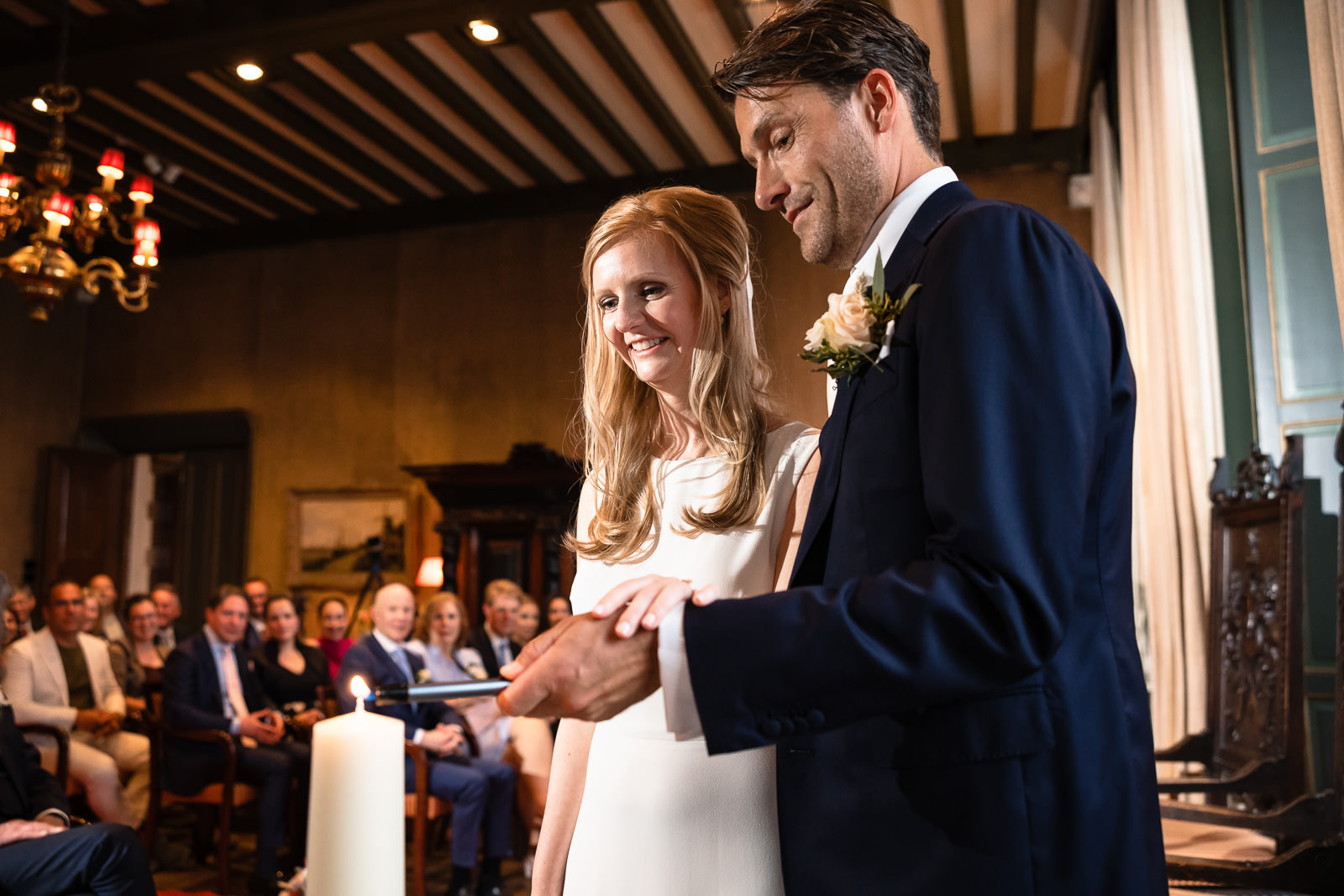 Binnen kasteel ceremonie bruidspaar steekt samen een kaars aan Trouwfotograaf Paco van Leeuwen