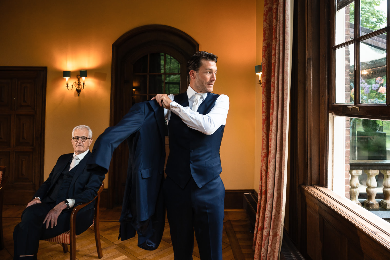 Bruidegom doet jas aan in kasteel Trouwfotograaf Paco van Leeuwen