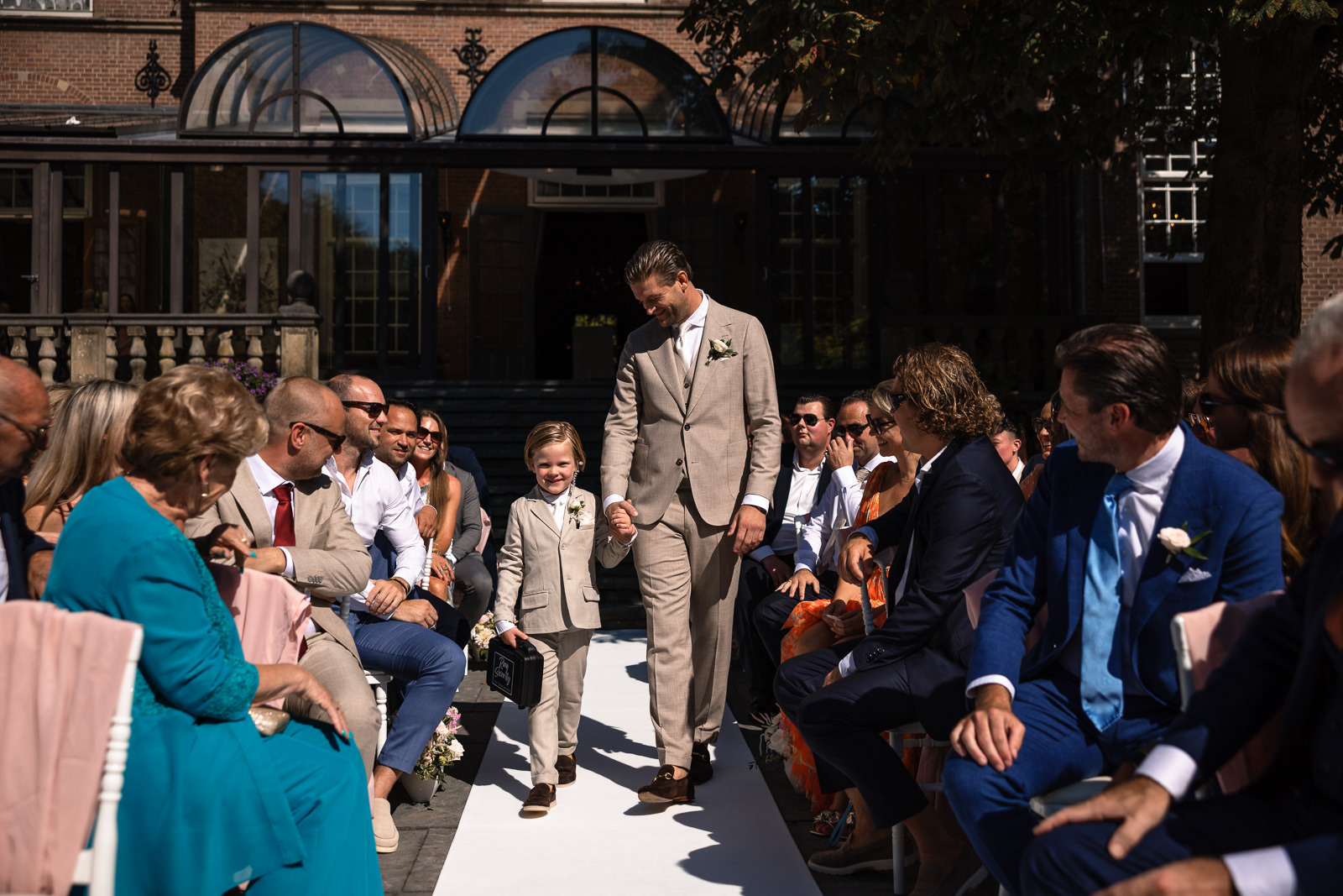 Opkomst bruidegom met zoontje voor romantische bruiloft ceremonie trouwfotograaf den haag