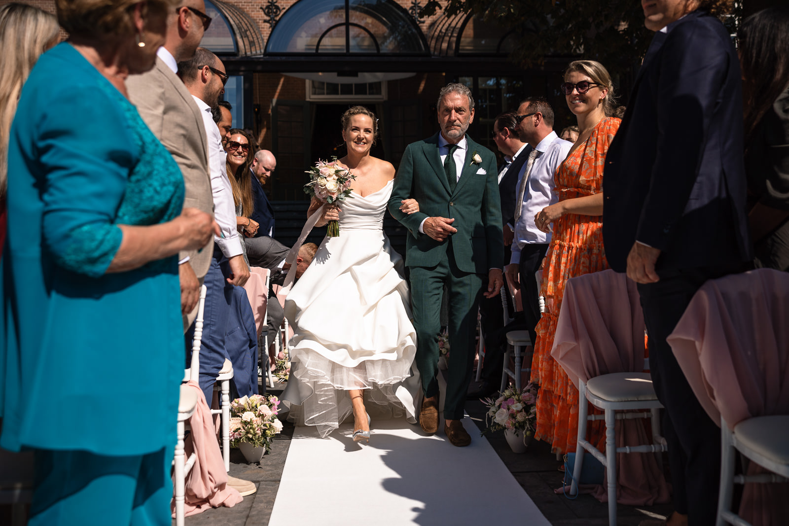 Opkomst bruid met vader voor romantische bruiloft ceremonie trouwfotograaf