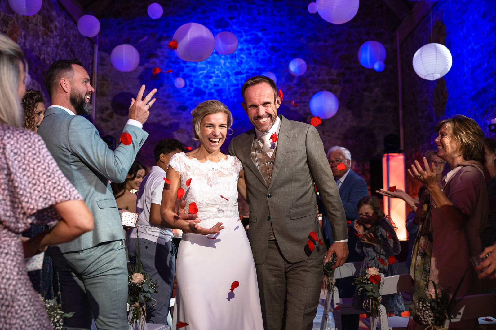 Trouwfotograaf Zuid-Limburg Hoeve Vernelsberg Ceremonie exit bruidspaar met bloem blaadjes